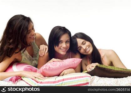 Three women lying on the bed and smiling