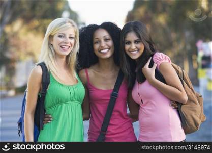 Three women outdoors standing with arms around each other (selective focus)