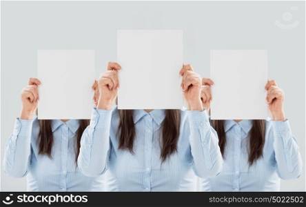Three women showing blank paper sheets in front of their heads