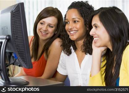 Three women sitting at a computer terminal (high key)