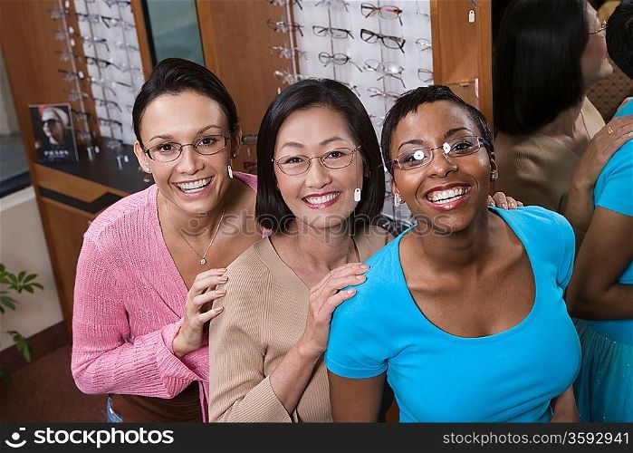 Three women wearing eyeglasses posing in store
