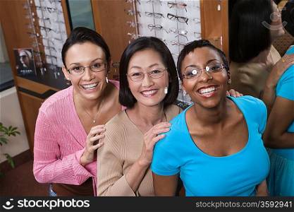 Three women wearing eyeglasses posing in store