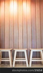 Three wooden chairs on wall background, stock photo