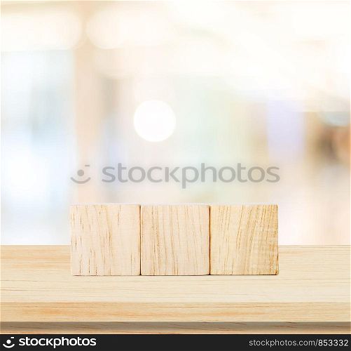Three wooden cubes on table and blur abstract background for text, business concept