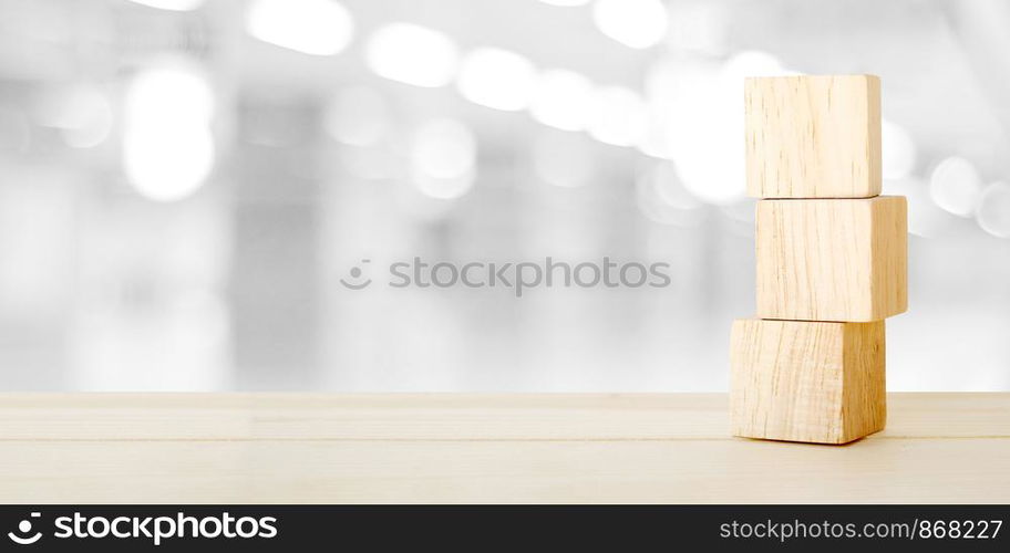 Three wooden cubes on table over blur abstract bokeh light background, mock up, template, banner with copy space for text