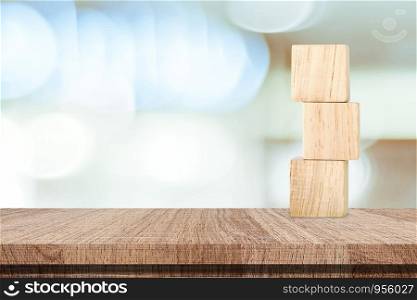 Three wooden cubes on table over blur abstract bokeh light background, mock up, template, banner with copy space for text