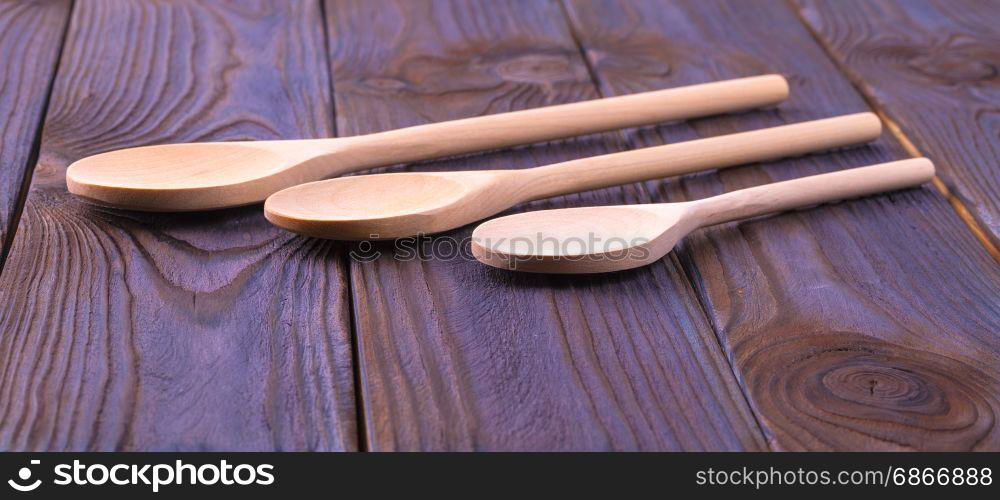 Three wooden spoons on a wooden table