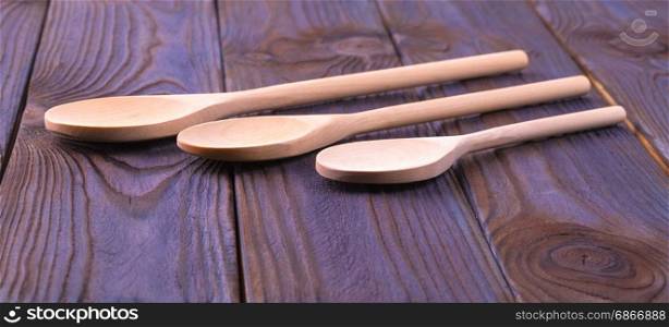 Three wooden spoons on a wooden table
