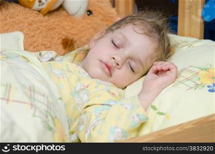 Three year old girl sweetly asleep in his crib in the nursery
