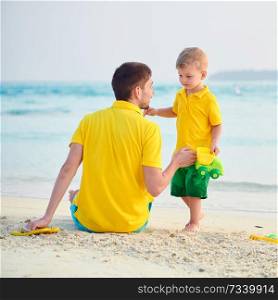 Three year old toddler boy on beach with father. Summer family vacation at Maldives.