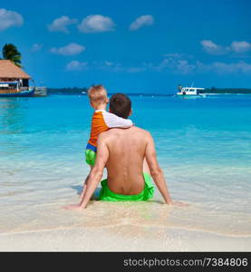 Three year old toddler boy on beach with father. Summer family vacation at Maldives.