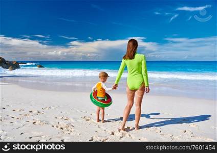 Three year old toddler boy on beach with mother. Summer family vacation at at Seychelles, Mahe.