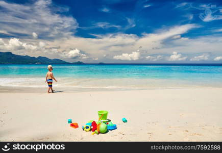 Three year old toddler boy playing with beach toys on beach. Summer family vacation at Seychelles, Mahe.