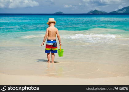 Three year old toddler boy playing with beach toys on beach. Summer family vacation at Seychelles, Mahe.