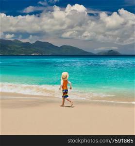 Three year old toddler boy running on beach. Summer family vacation at Seychelles, Mahe.