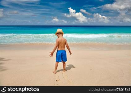 Three year old toddler boy walking on beach. Summer family vacation at Seychelles, Mahe.