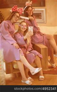 three young beautiful happy girls doing Selfy on bachelorette party at a luxury spa with champagne