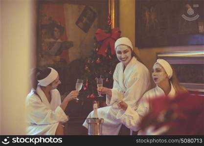 three young beautiful happy girls have a bachelor party at a luxury spa with champagne