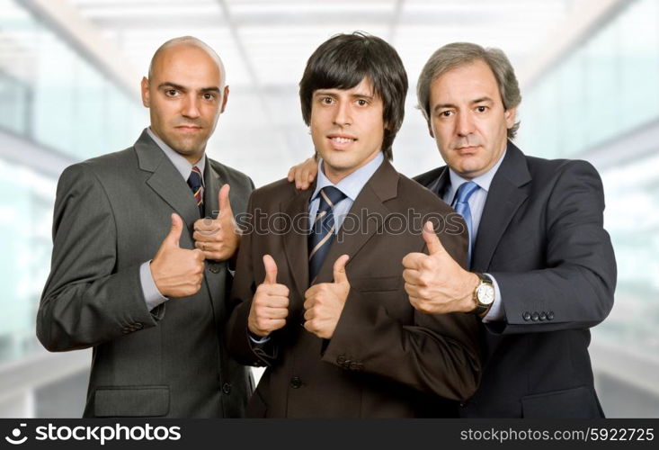 three young business men going thumbs up, at the office