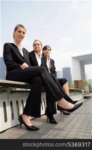 Three young businesswomen sitting on a bench