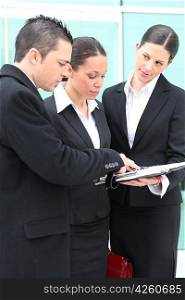 Three young executives standing outside a workplace