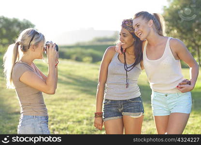 Three young female friends posing for photographs