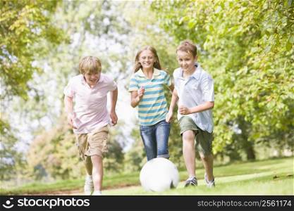 Three young friends playing soccer