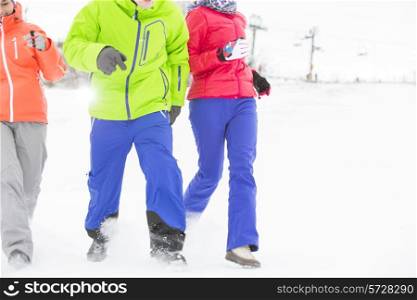 Three young friends running in snow