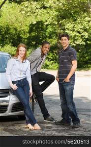 Three young friends with a car