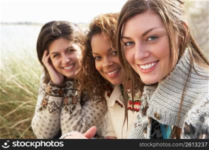 Three Young Girls Sitting In Sand Dunes Together