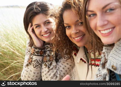 Three Young Girls Sitting In Sand Dunes Together