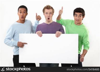 Three young guys with sign