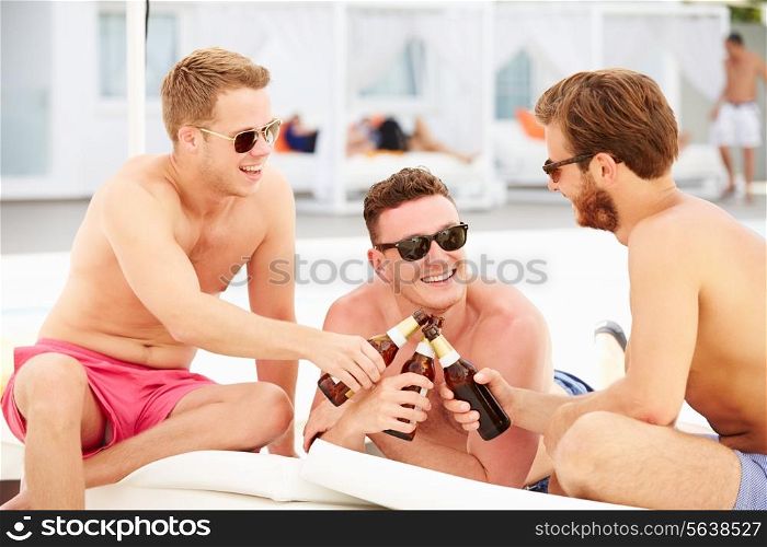 Three Young Male Friends On Holiday By Pool Together