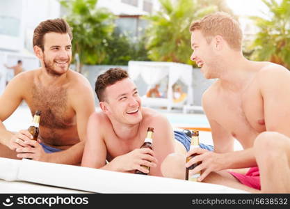 Three Young Male Friends On Holiday By Pool Together