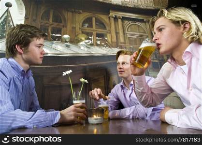 three young men drinking beer in a bar