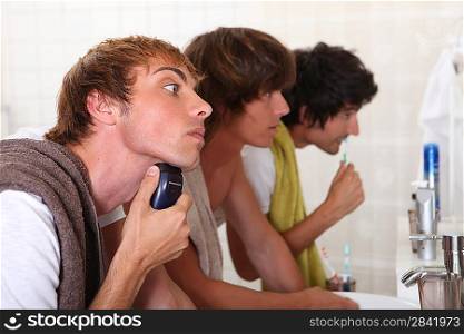 Three young men in the bathroom getting ready to go out