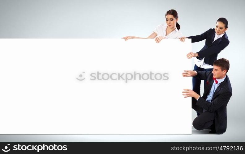 Three young people holding banner. Image of three young people holding blank banner. Place for text