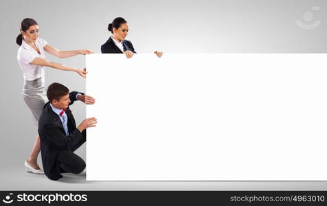 Three young people holding banner. Image of three young people holding blank banner. Place for text