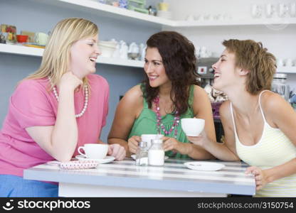 Three young woman sitting at a table and drinking tea