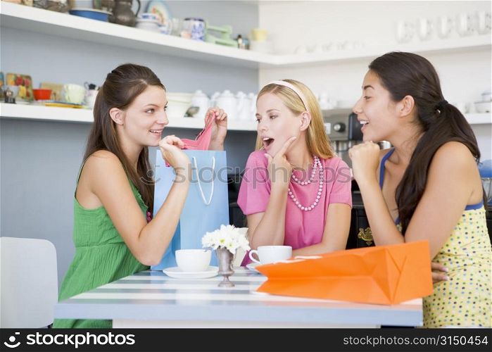 Three young woman sitting at a table taking a break from shopping