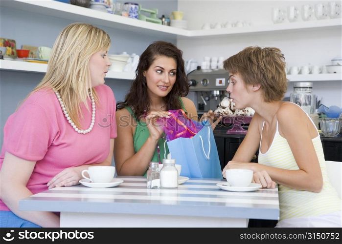 Three young woman sitting at a table taking a break from shopping