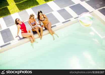 Three young women by the pool  at sunny day