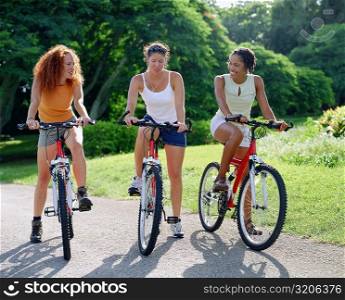 Three young women cycling, Bermuda