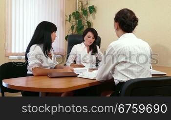 Three Young Women Discussing Business Issues in Office