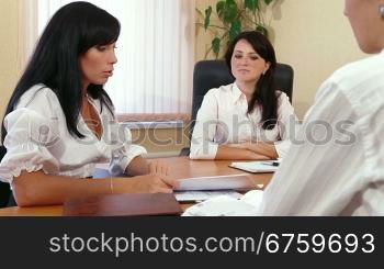 Three Young Women Discussing Business Issues in Office