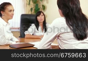 Three Young Women Discussing Business Issues in Office, Focus on Foreground