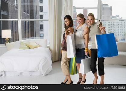 Three young women holding shopping bags