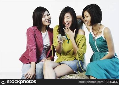 Three young women looking at a digital camera