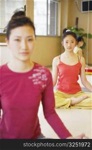 Three young women sitting in the lotus position