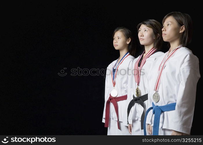 Three young women standing with their medals